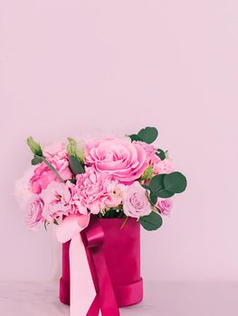 Beautiful bouquet of blooming flowers in flower box on pink background, holiday gift, luxury floral design concept