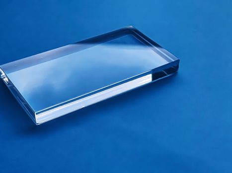 Transparent glass device on blue background, future technology and abstract screen mockup design concept