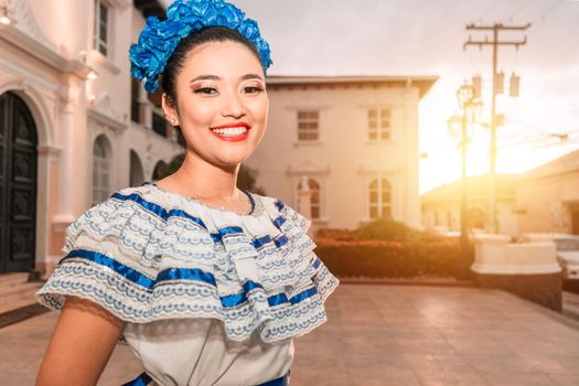 Traditional dancer from Nicaragua. Latin girl smiling with the traditional dress of Mexico, Central and South America, looking at the camera at sunset.