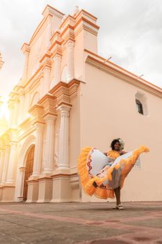 Vertical photo of a curly-haired mestizo traditional dancer with a typical Nicaraguan costume dancing outside La Merced cuhrch of Leon Nicaragua during the independence festivities of CentralAmerica.