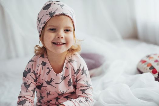Child in soft warm pajama playing in bed