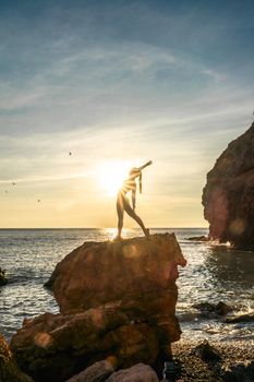 Girl gymnast is training on the beach by the sea sunset. Does twine. Photo series