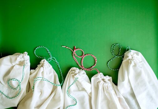 zero waste products in reusable cotton bags on a green background. High quality photo