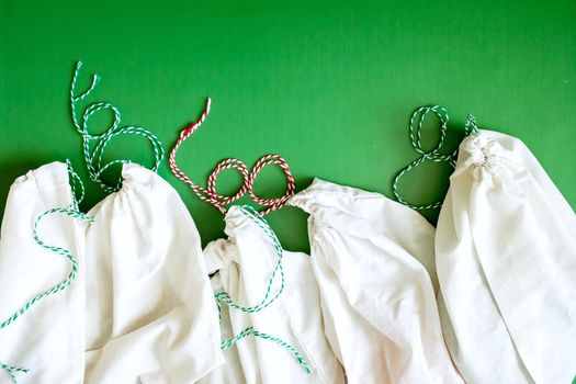 zero waste products in reusable cotton bags on a green background. High quality photo