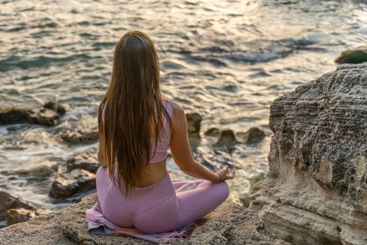 Young woman practicing yoga outdoors. Harmony and meditation concept. Healthy lifestyle.