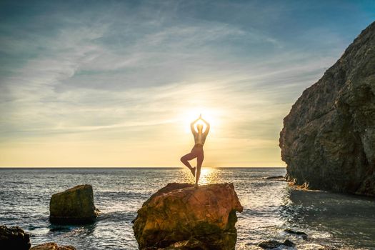 Girl gymnast is training on the beach by the sea sunset. Does twine. Photo series