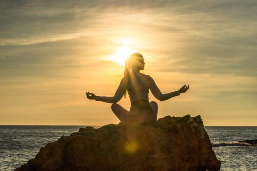 Young woman practicing yoga outdoors. Harmony and meditation concept. Healthy lifestyle.