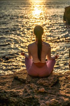 Young woman practicing yoga outdoors. Harmony and meditation concept. Healthy lifestyle.