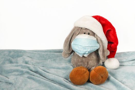 Plush toy in a mask and Christmas hat. Flu colds disease virus bacterium. Plush donkey toy wear protection mask and Santa hat, Protect Against Coronavirus concept