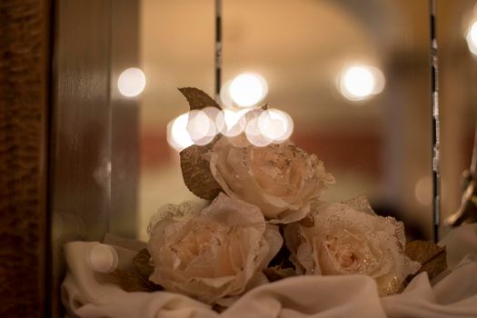 Artificial flowers in a display case with bokeh effect with lights reflection