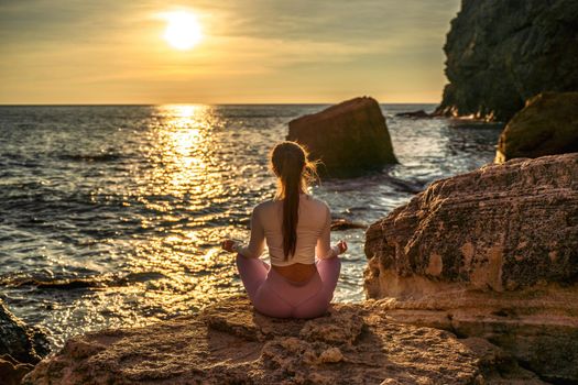 Young woman practicing yoga outdoors. Harmony and meditation concept. Healthy lifestyle.