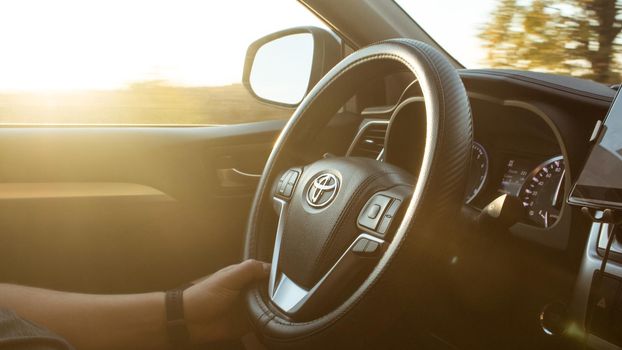 Man is driving vehicle with sun flare from the outside in the sunny day.