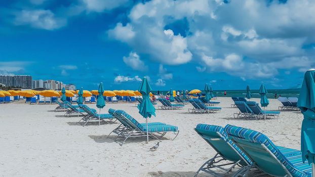 Photo of beautiful Miami beach area with umbrellas and lounge chairs