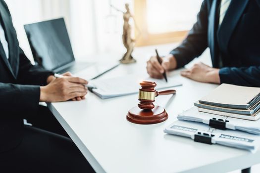 Focus at gavel, Attorney or Lawyer holding a pen is consulting with a client to explain the pattern of answering questions before going to court to decide a lawsuit