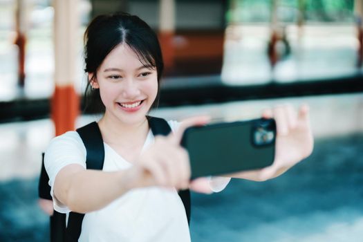 summer, relax, vacation, travel, portrait of beautiful Asian girl using the smartphone mobile take a photo selfie face yourself at the train station while waiting for their travel time