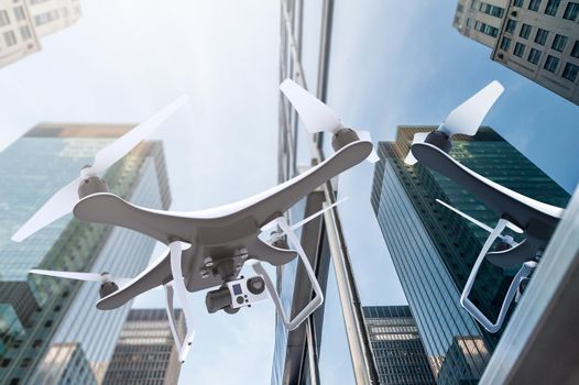 Drone with digital camera flying near modern skyscrapers: 3D rendering