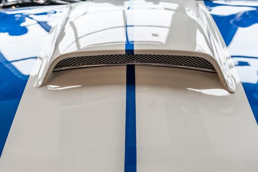 Closeup on hood of a blue and white sport car