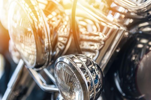 Headlight of a powerful vintage motorbike in the sunlight