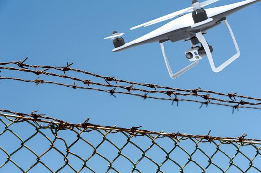 Drone with digital camera flying over a barbed wire fence: 3D rendering