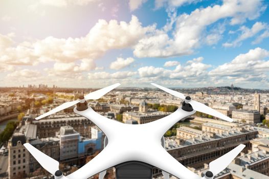 Drone with digital camera flying over a city with blue sky: 3D rendering