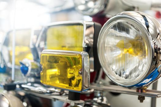 Many headlights of a powerful vintage motorbike in the sunlight