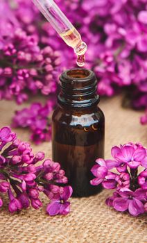 Lilac essential oil in a small bottle. Selective focus. Nature.
