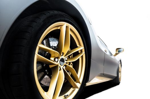 Close up of a tire of a black car with golden rim