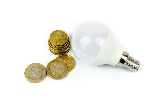 Led light bulb next to euro coins on white background