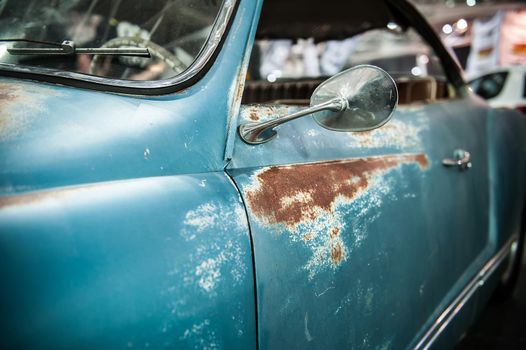 Close up of a vintage blue car with rust