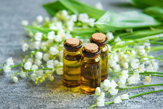Lily of the valley essential oil in a small bottle. Selective focus. Nature.