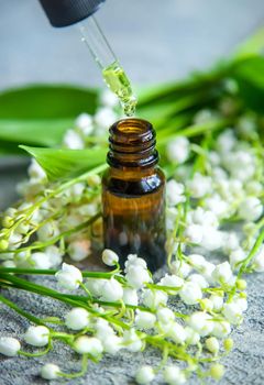 Lily of the valley essential oil in a small bottle. Selective focus. Nature.