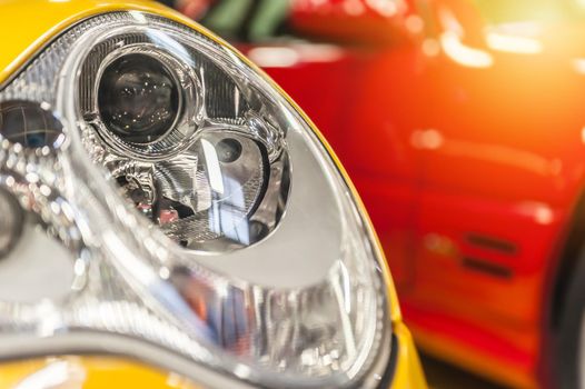 Closeup on an headlight of a yellow sport car