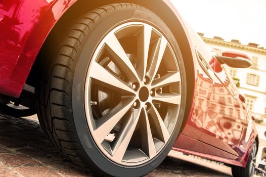 Close up of a tire of a red car in sunset