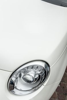 Close up of headlights of a white city car