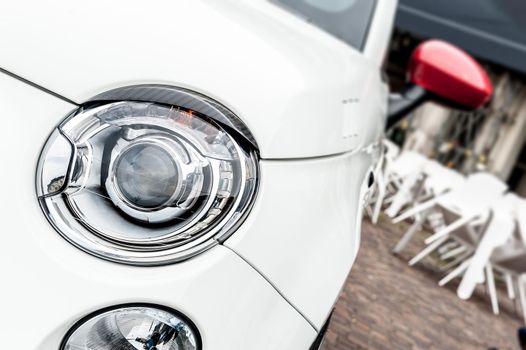 Close up of headlights of a white city car