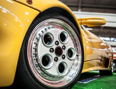 Front of a yellow sport car in a salon