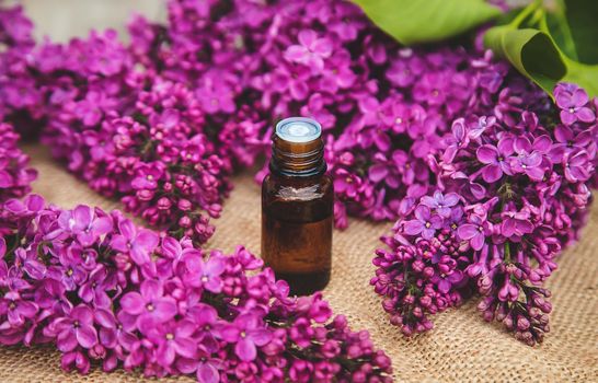 Lilac essential oil in a small bottle. Selective focus. Nature.