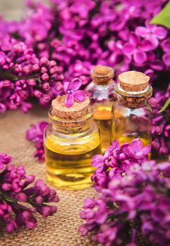 Lilac essential oil in a small bottle. Selective focus. Nature.