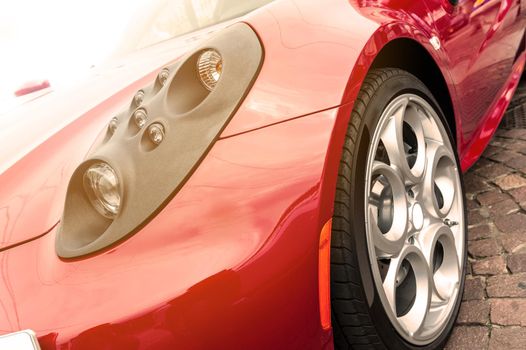 Close up of a tire of a red car in sunset