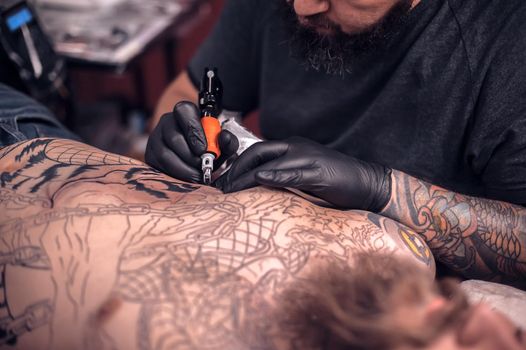 Tattooist makes a tattoo tattoo parlor.