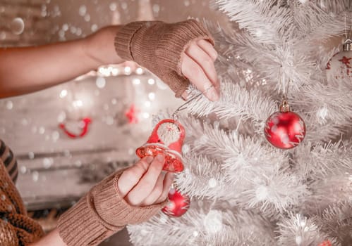 Young woman decorating Christmas tree at home