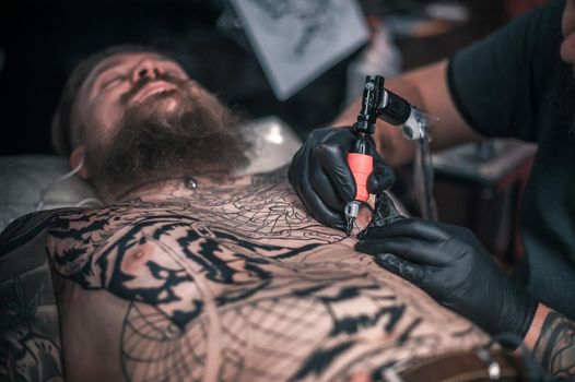 Tattoo specialist posing in tattoo parlour.