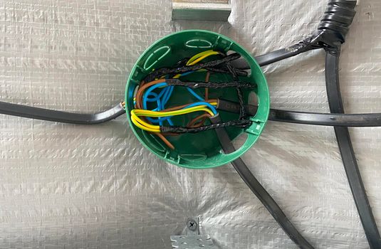 Electrical wiring of the junction box, installation, twisting of the box by an electrician. Selective focus.