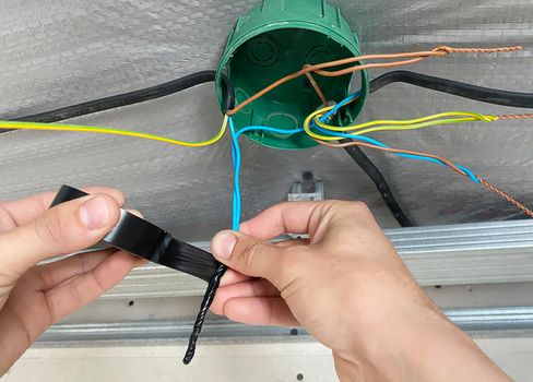 Electrical wiring of the junction box, installation, twisting of the box by an electrician. Selective focus.