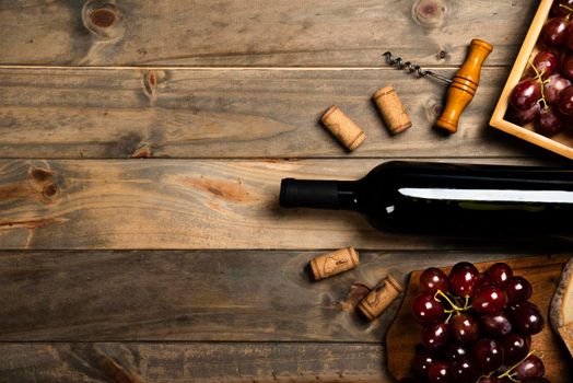 flat lay bottle wine surrounded by corks red grapes