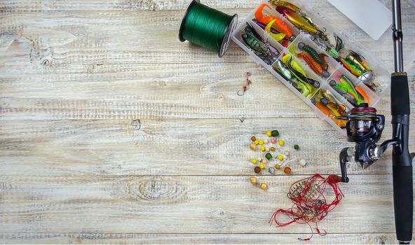 lot of colorful lures with the fishing rod on the wooden pier