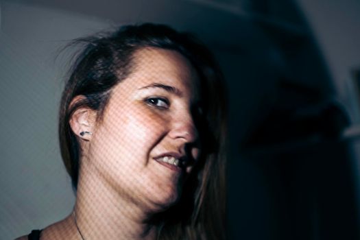 Portrait of the face of a young woman smiling in the foreground in a photographic studio. happy people concept