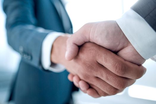 Close up view of business partnership handshake concept.Photo of two businessman handshaking process.Successful deal after great meeting.