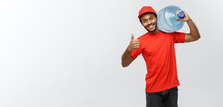 Delivery Concept - Handsome African American delivery man holding water tank. Isolated on Grey studio Background. Copy Space