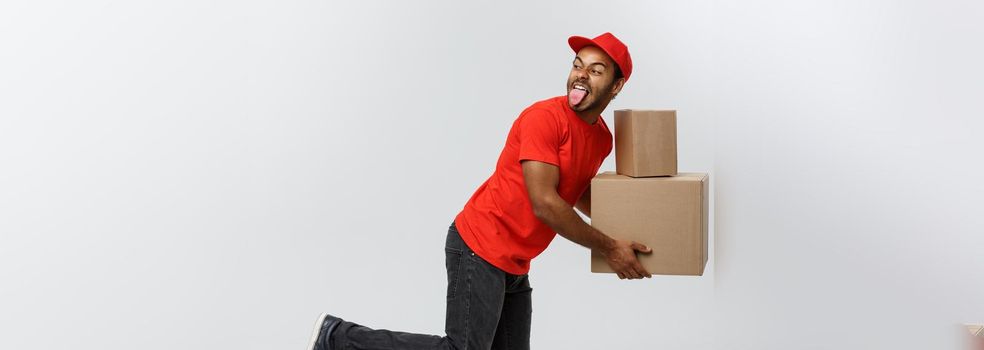 Delivery Concept - Handsome African American delivery man rush running for delivering a package for customer. Isolated on Grey studio Background. Copy Space